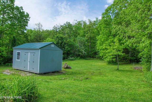 634 Robs Rd, Grimsley, TN 38565 - view of green lawn with an outdoor structure, a storage shed, and a forest view