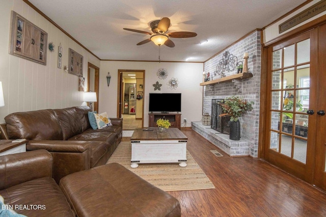 7745 Keswick Rd, Powell, TN 37849 - living room with ornamental molding, wood finished floors, ceiling fan, and a brick fireplace