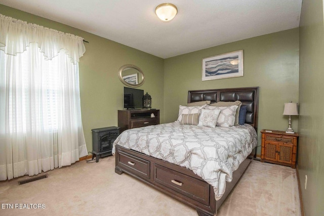 7745 Keswick Rd, Powell, TN 37849 - bedroom with light colored carpet, a wood stove, and baseboards