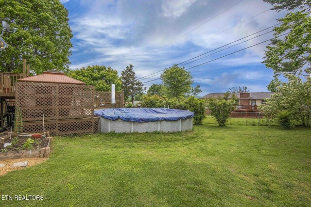 7745 Keswick Rd, Powell, TN 37849 - view of grassy yard featuring a wooden deck and a vegetable garden