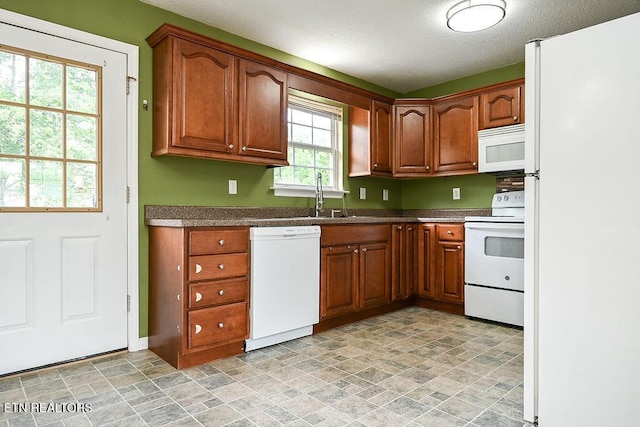169 Claire St, Benton, TN 37307 - kitchen featuring white appliances, stone finish flooring, a sink, dark countertops, and brown cabinets