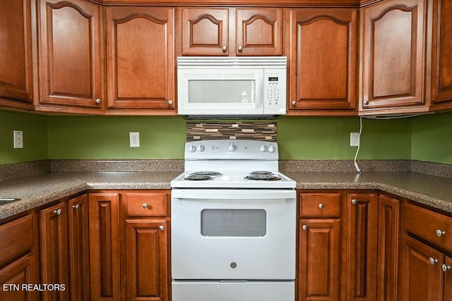 169 Claire St, Benton, TN 37307 - kitchen with white appliances, dark countertops, and brown cabinets