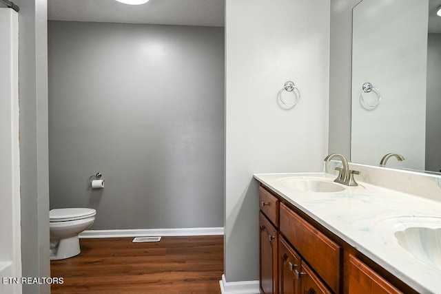 169 Claire St, Benton, TN 37307 - full bathroom featuring wood finished floors, toilet, baseboards, and double vanity