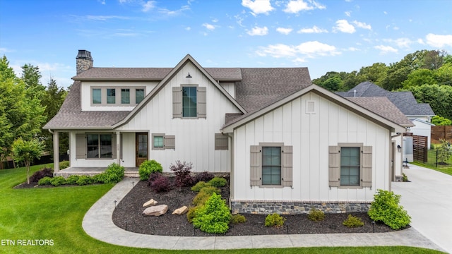 209 Fence Post Ln, Knoxville, TN 37934 - view of front of property featuring board and batten siding, roof with shingles, covered porch, and a front lawn