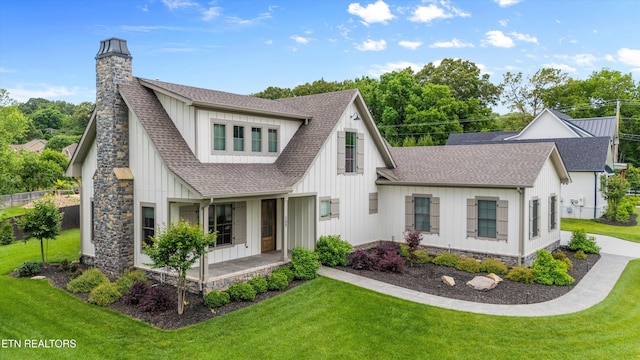 209 Fence Post Ln, Knoxville, TN 37934 - view of front of house featuring a shingled roof, a front lawn, board and batten siding, a chimney, and covered porch