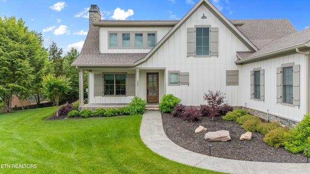 209 Fence Post Ln, Knoxville, TN 37934 - view of front of house with board and batten siding, roof with shingles, a chimney, a front lawn, and a porch