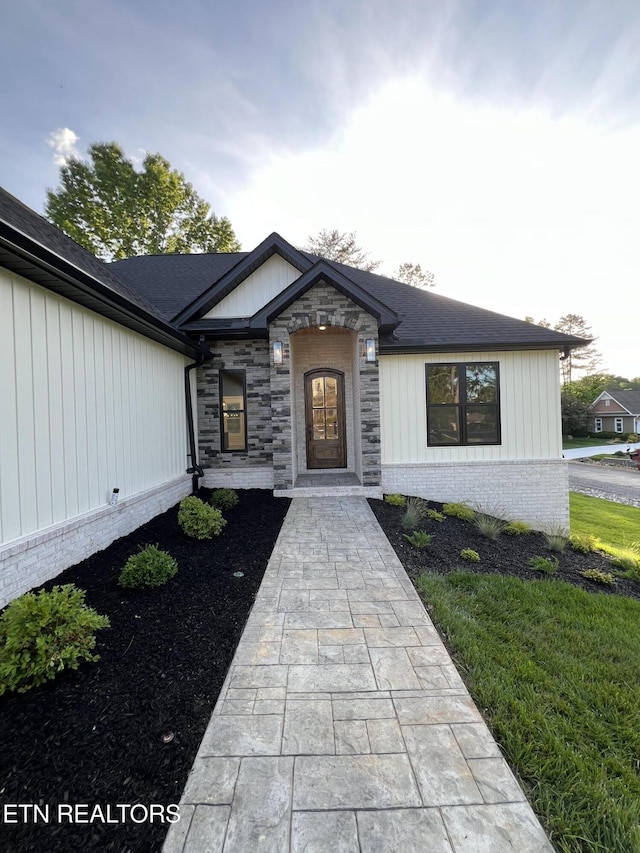 view of front of home with brick siding and roof with shingles