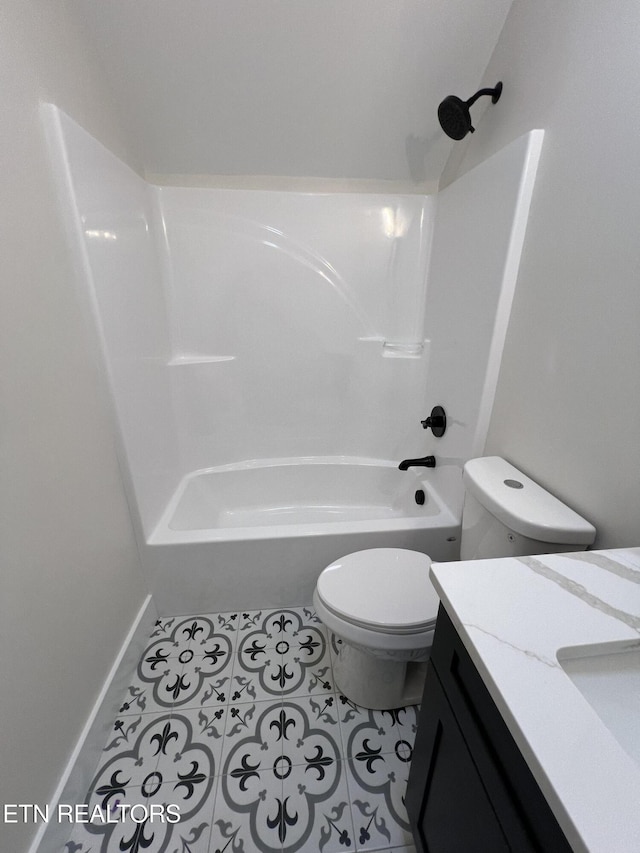 bathroom with tile patterned flooring, toilet, vanity, shower / washtub combination, and baseboards