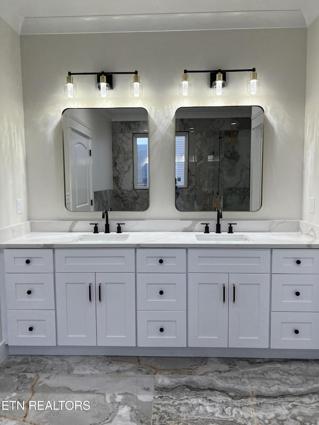 bathroom with marble look tile flooring, a marble finish shower, and double vanity