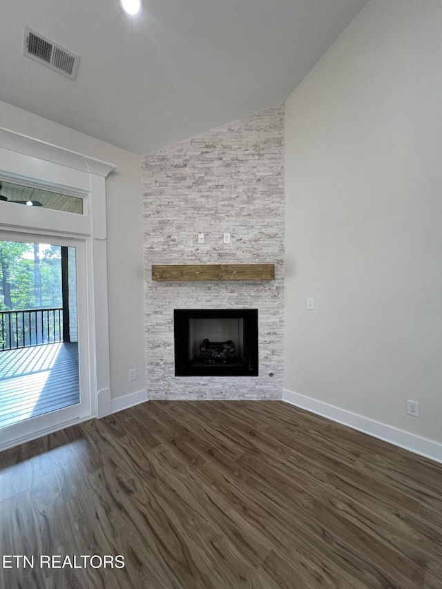 unfurnished living room with lofted ceiling, baseboards, wood finished floors, and a fireplace