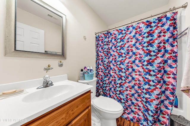 bathroom featuring toilet, vanity, and curtained shower