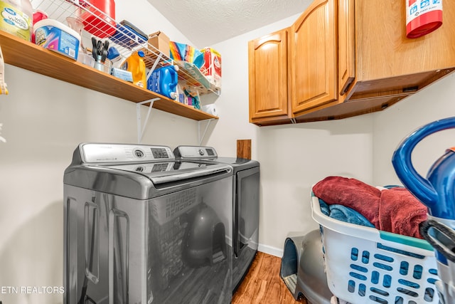 washroom with independent washer and dryer, light wood finished floors, cabinet space, and baseboards