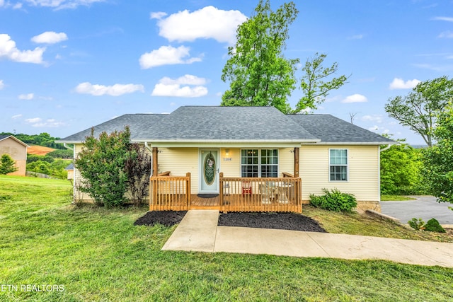 bungalow-style house featuring a deck, a front yard, and a shingled roof