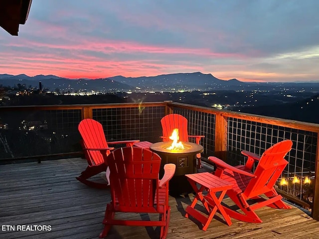 deck at dusk featuring a fire pit and a mountain view