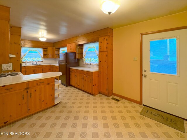 161 Cedar Ln, Rocky Top, TN 37769 - kitchen featuring open shelves, light countertops, freestanding refrigerator, white electric cooktop, and brown cabinets