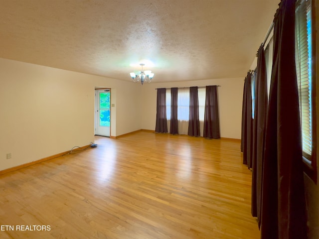 161 Cedar Ln, Rocky Top, TN 37769 - empty room featuring a chandelier, light wood finished floors, a textured ceiling, and baseboards