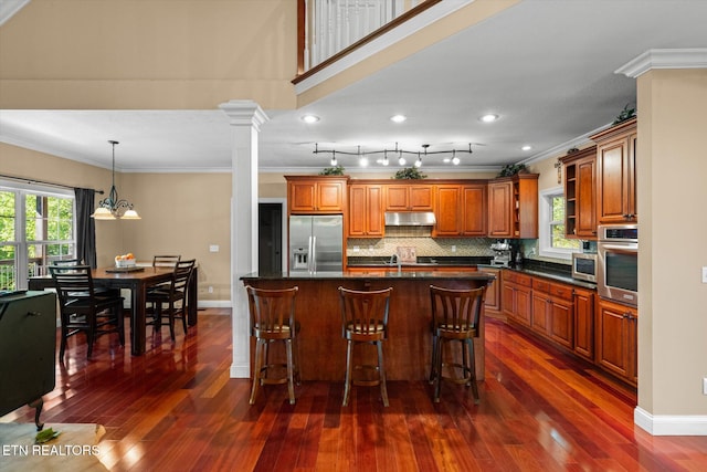 1090 Snow Hill Rd, Oakdale, TN 37829 - kitchen with appliances with stainless steel finishes, crown molding, under cabinet range hood, brown cabinets, and dark wood-style floors