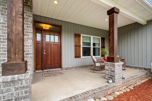 doorway to property with covered porch and board and batten siding