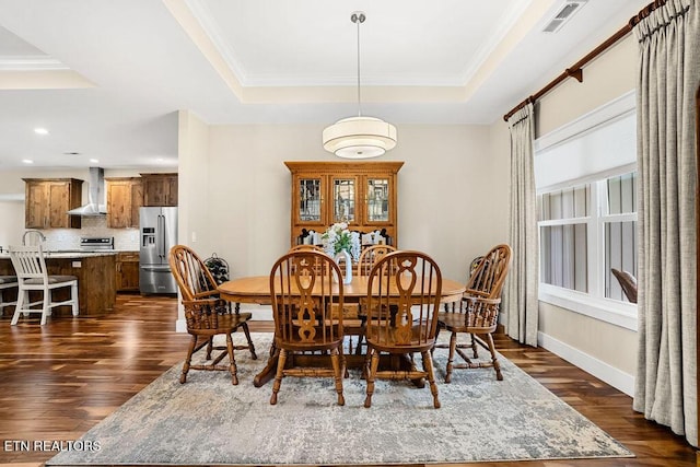 dining area with a tray ceiling, dark wood-style floors, ornamental molding, baseboards, and recessed lighting