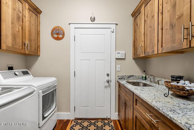 washroom featuring cabinet space, washer and clothes dryer, dark wood-type flooring, and baseboards
