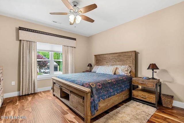 bedroom with baseboards, wood finished floors, and a ceiling fan
