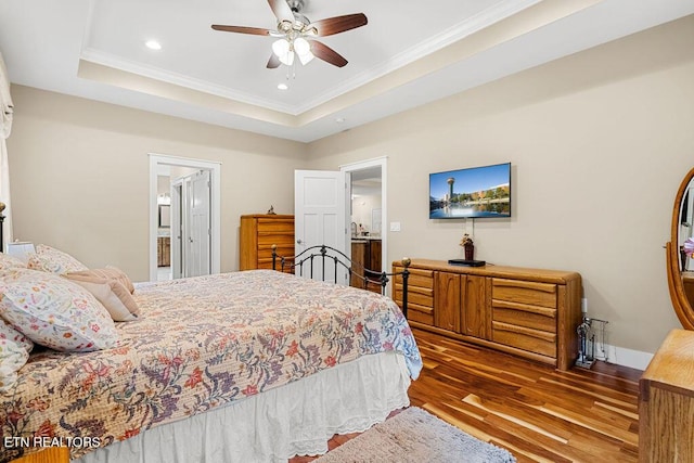bedroom featuring wood finished floors, ornamental molding, recessed lighting, a tray ceiling, and a ceiling fan