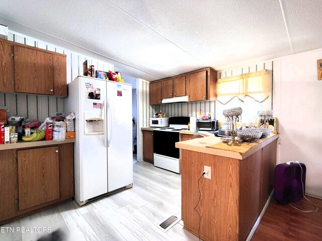 3497 Whittaker Rd, Cookeville, TN 38506 - kitchen featuring white appliances, under cabinet range hood, a textured ceiling, light countertops, and light wood-style floors