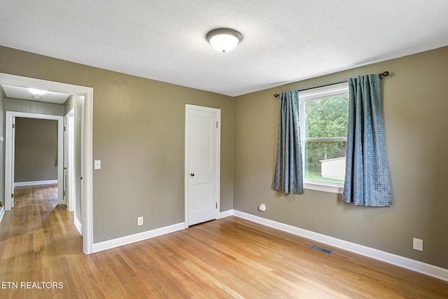 5629 Neubert Springs Rd, Knoxville, TN 37920 - unfurnished bedroom with light wood-type flooring, baseboards, and a textured ceiling