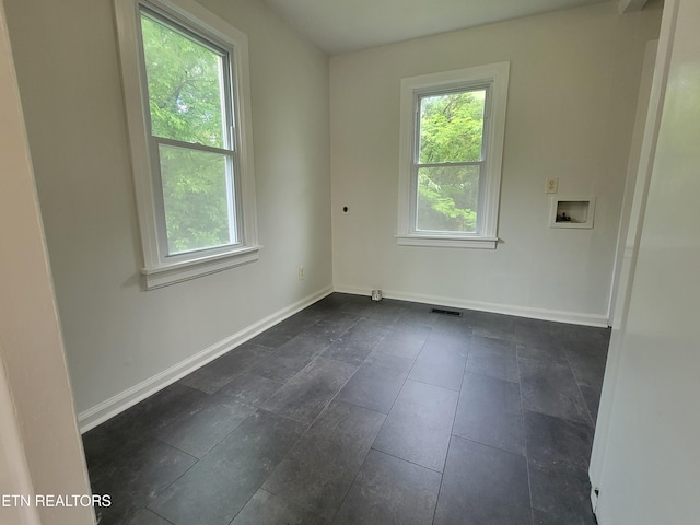 spare room with healthy amount of natural light and baseboards