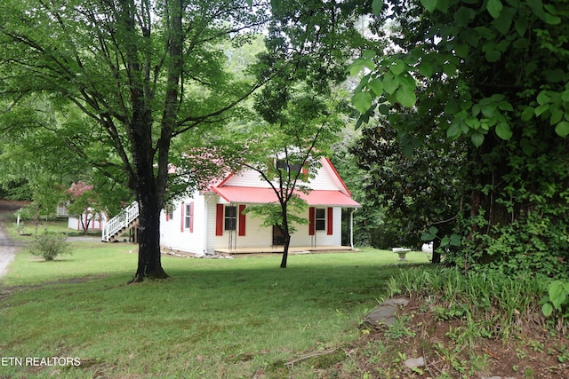 obstructed view of property with a front yard and metal roof