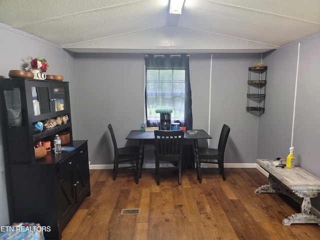 dining room featuring wood finished floors, vaulted ceiling, and baseboards