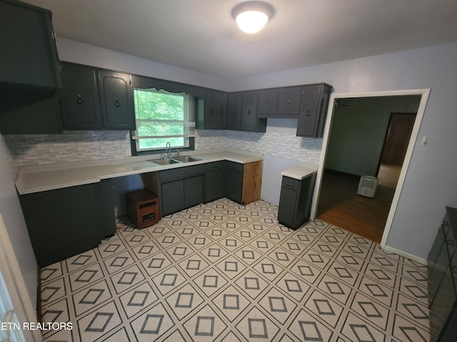 kitchen featuring a sink, tasteful backsplash, and light countertops