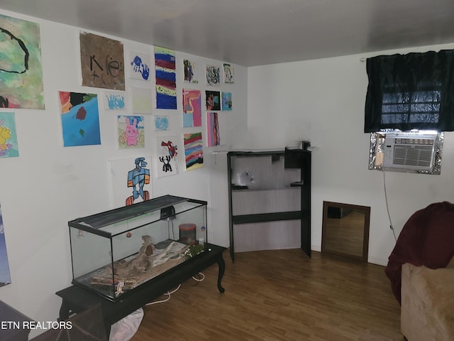interior space featuring wood finished floors, cooling unit, and baseboards
