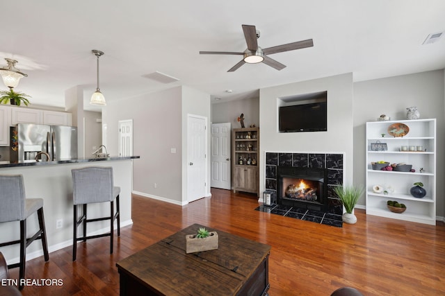 10737 Prince Albert Way, Knoxville, TN 37934 - living area with a ceiling fan, dark wood-style flooring, a tile fireplace, and baseboards