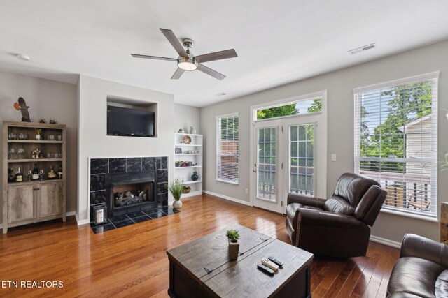 10737 Prince Albert Way, Knoxville, TN 37934 - living area featuring wood finished floors, a tile fireplace, ceiling fan, and baseboards