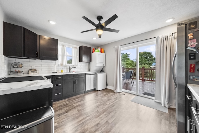 2007 NE Albert Ave, Knoxville, TN 37917 - kitchen featuring stainless steel appliances, stacked washer / dryer, a sink, light wood-type flooring, and ceiling fan