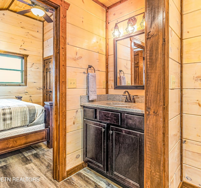 bathroom featuring wood walls, wood finished floors, and vanity