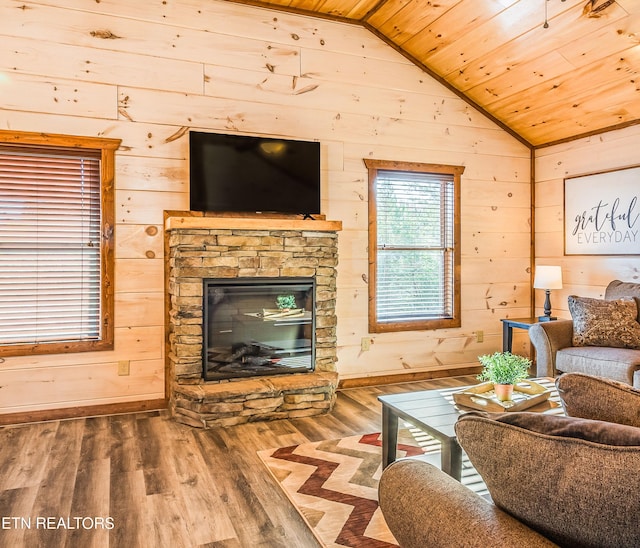 living area featuring wood ceiling, vaulted ceiling, wood finished floors, baseboards, and wooden walls