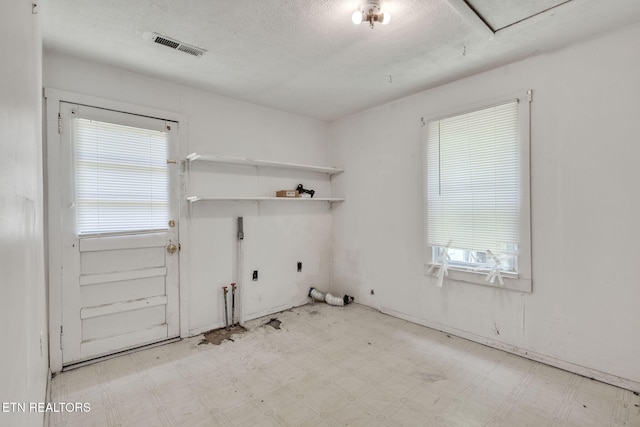 401 Offutt Spur Rd, Rocky Top, TN 37769 - laundry room with gas dryer hookup, tile patterned floors, electric dryer hookup, plenty of natural light, and a textured ceiling