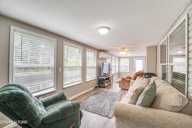 1418 Gulley River Rd, Harrogate, TN 37752 - living area featuring a wall unit AC, baseboards, a ceiling fan, and wood finished floors