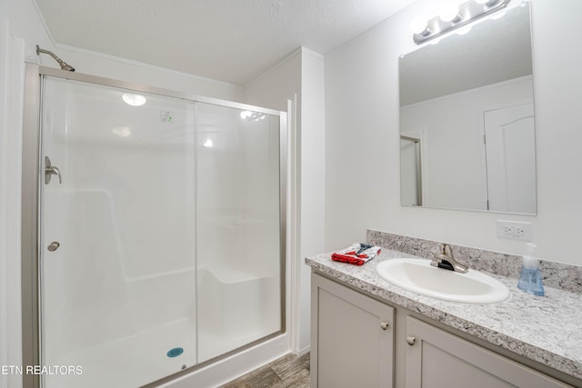 1418 Gulley River Rd, Harrogate, TN 37752 - bathroom featuring a stall shower, wood finished floors, vanity, ornamental molding, and a textured ceiling