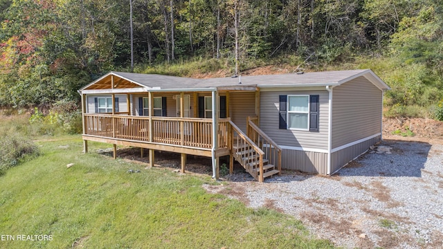 1418 Gulley River Rd, Harrogate, TN 37752 - manufactured / mobile home with covered porch, a front yard, and a view of trees