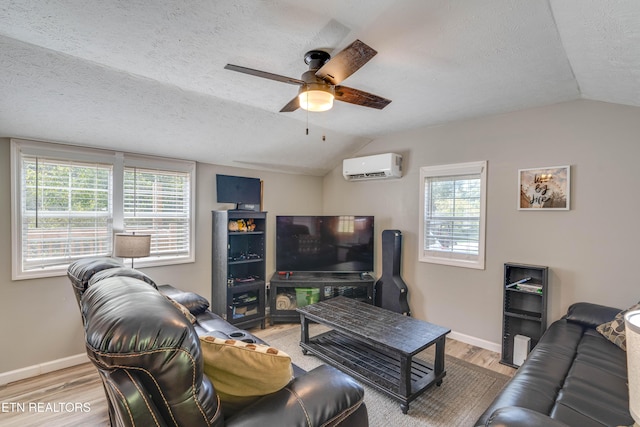 1418 Gulley River Rd, Harrogate, TN 37752 - living room featuring vaulted ceiling, an AC wall unit, a textured ceiling, ceiling fan, and wood finished floors