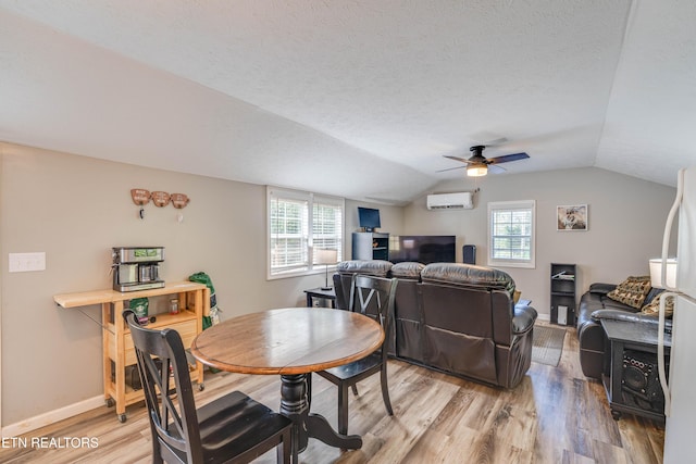 1418 Gulley River Rd, Harrogate, TN 37752 - dining area featuring an AC wall unit, light wood-style flooring, lofted ceiling, plenty of natural light, and a ceiling fan