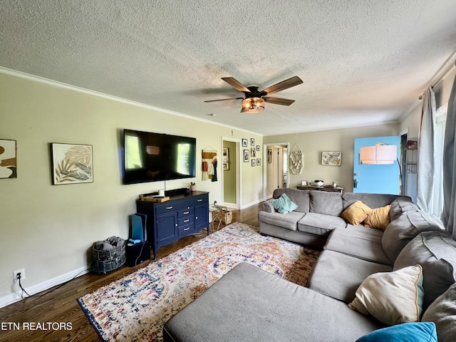 living room featuring a ceiling fan, dark wood-style floors, baseboards, crown molding, and a textured ceiling