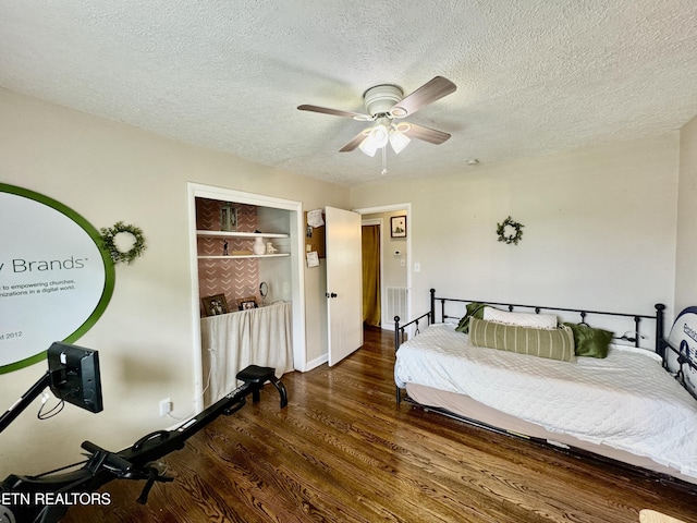 bedroom with a textured ceiling, wood finished floors, and a ceiling fan