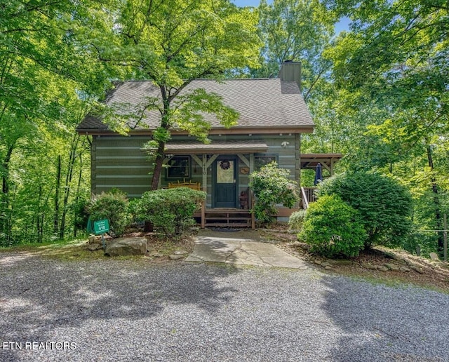 410 Sassafras Trl, Sevierville, TN 37876 - view of front facade with a chimney, covered porch, and a shingled roof