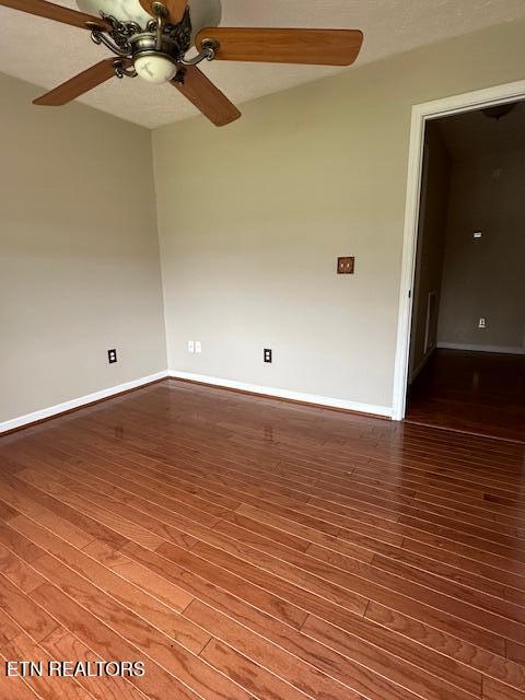 spare room with a ceiling fan, baseboards, and wood finished floors