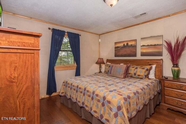 bedroom with wood finished floors and crown molding