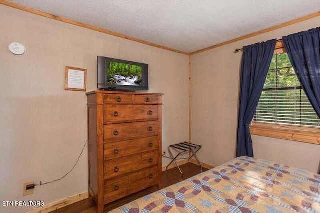 bedroom with crown molding and a textured ceiling
